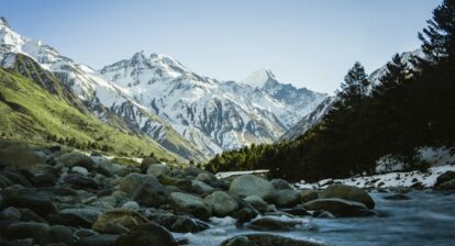 Photo of a valley in the Himalayas with a river flowing through it.