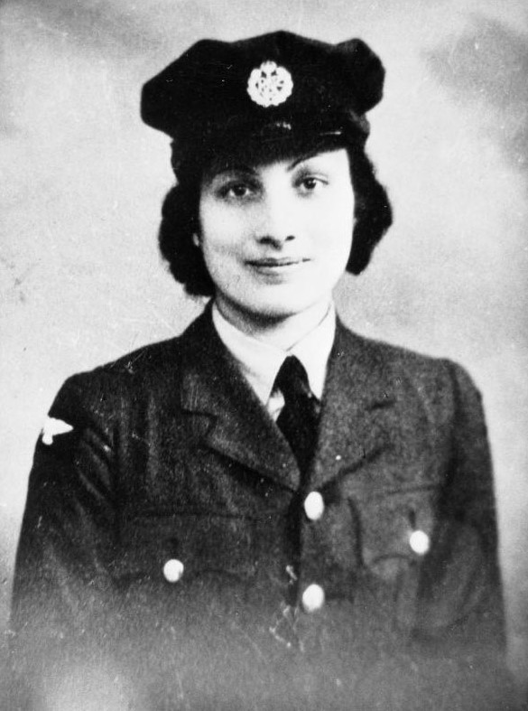 Hon. Assistant Section Officer Noor Inayat Khan (code name Madeleine), George Cross, MiD, Croix de Guerre avec Etoile de Vermeil. Noor Inayat Khan served as a wireless operator with F Section, Special Operations Executive. Black and white image, with Noor smiling, facing the camera, in her unifrom.