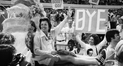 Billie Jean King being carried onto the court on a litter before the match